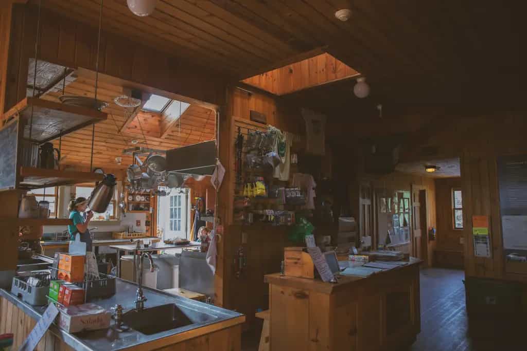 Interior of Galehead Hut with wood paneling, kitchen area, and retail display.