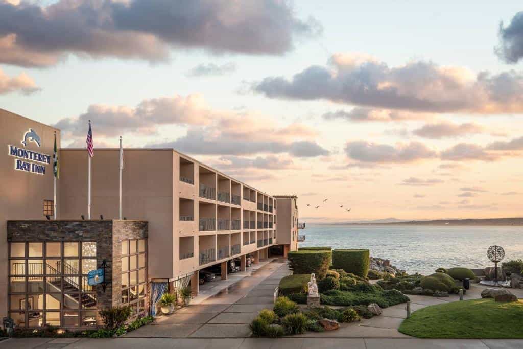 Monterey Bay Inn hotel building overlooking the ocean at sunset.