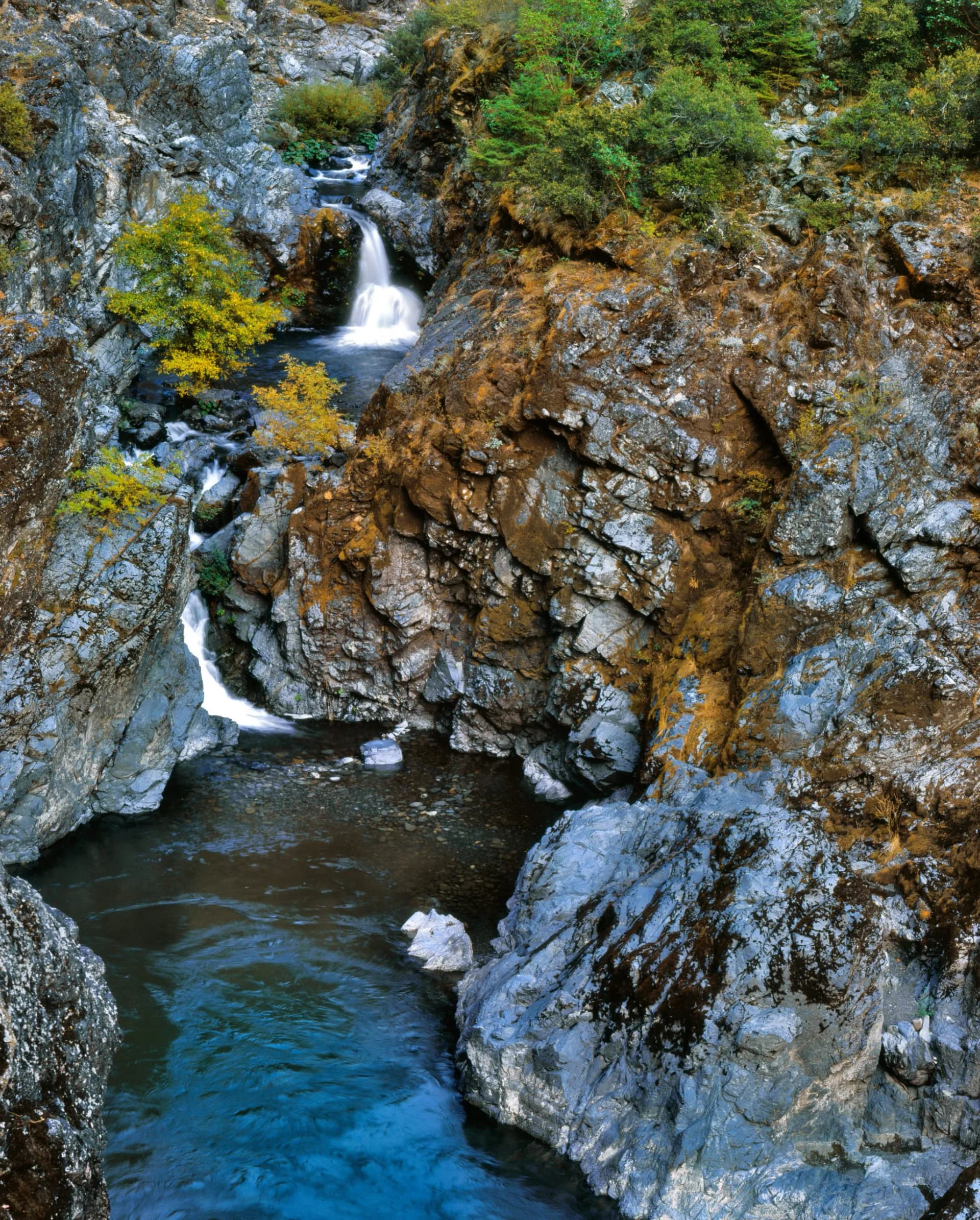 Stair Creek Falls along the Rogue River with steep rocky canyon walls and autumn foliage.