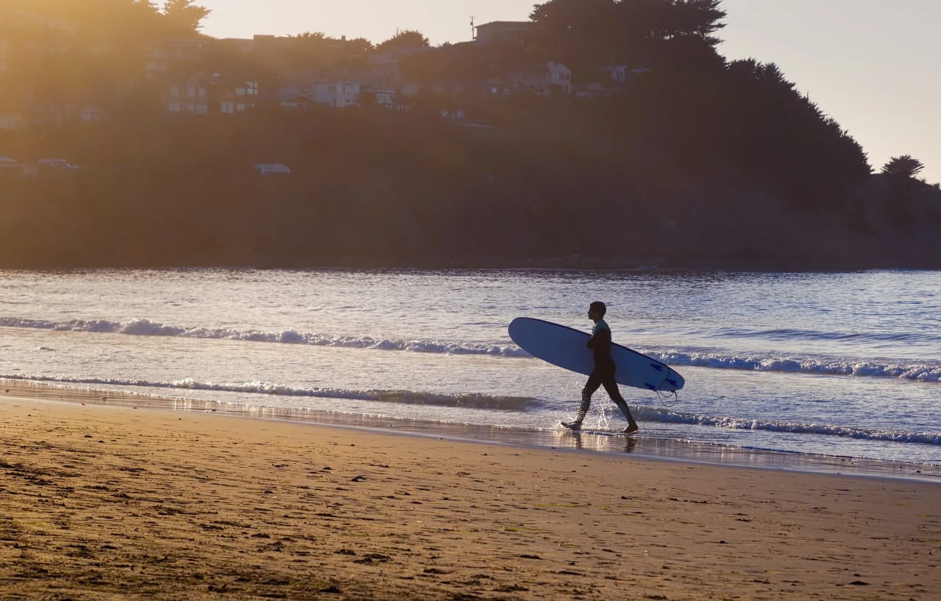 Surfer Walking Along the Beach